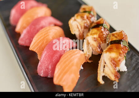 Sushi nigiri mit Lachs, Thunfisch und Aal. Nahaufnahme von köstliches Sushi mit Fisch auf dem Teller. Restaurant mit Meeresfrüchten. Stockfoto