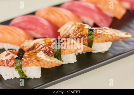 Köstliches Sushi mit Aal an der Platte. Sushi nigiri mit Aal, Lachs und Thunfisch. Stockfoto