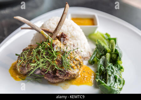 Gegrilltes Lamm Steak mit würzigen gelben Sause und grünes Gemüse auf Jasmin Reis. Stockfoto