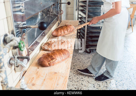 Frau in der Bäckerei, Brot an Bord Stockfoto