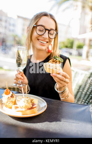 Frau essen Spanische pinchos an der Bar im Freien Stockfoto