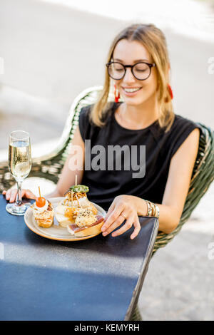 Frau essen Spanische pinchos an der Bar im Freien Stockfoto