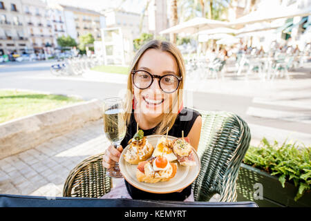 Frau essen Spanische pinchos an der Bar im Freien Stockfoto