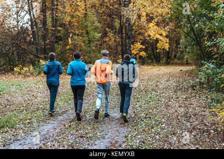 Ausführen von Athleten in den Park an einem Lauf in den frühen Morgen. Mehrere Kinder laufen im Wald Sport. Gesunde Lebensweise. Stockfoto