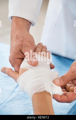 Nahaufnahme der Person Hand wickeln Verband zu Patient Stockfoto