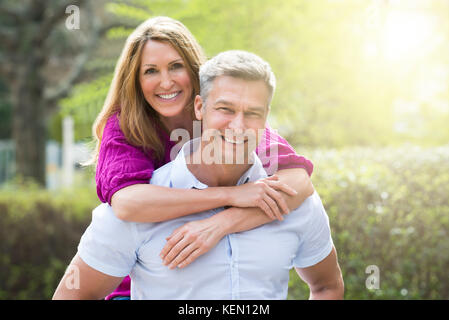 Portrait von Frau ihrem Mann umarmt von hinten Stockfoto