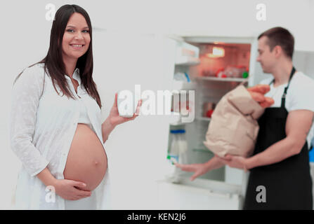 Schwangere Frau und Mann beim Frühstück in der Küche Stockfoto