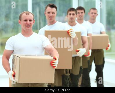 Team von Bauherren mit Boxen von Baustoffen Stockfoto