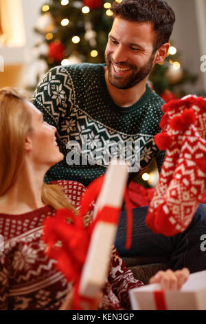 Fröhlicher Mann, der Weihnachten Socken als Geschenk für Frau Stockfoto