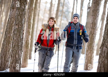 Wanderer Paar im Winter mit Stöcken Wandern im Wald Stockfoto