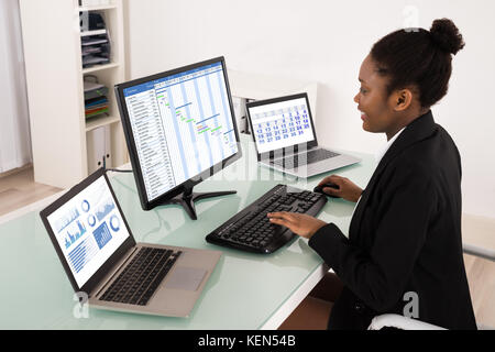 Junge afrikanische Geschäftsfrau auf Gantt-diagramm arbeiten im Büro Stockfoto