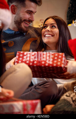 Fröhliche romantisches Paar Austausch geschenkboxen an Heiligabend Stockfoto