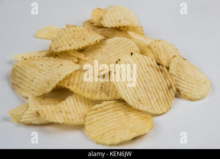 Stapel der zerknitterten wellig Kartoffelchips auf weißem Hintergrund Stockfoto