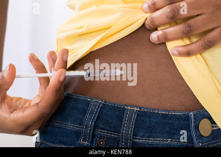 Nahaufnahme einer jungen Diabetiker afrikanische Frau Injektion von Arm Stockfoto