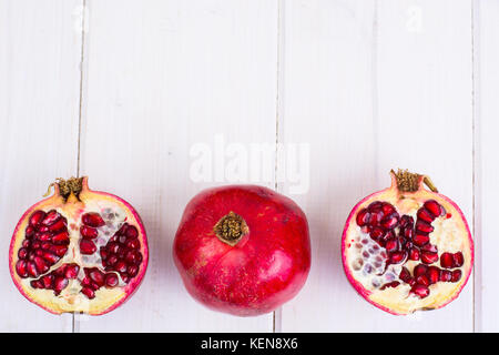 Granatapfel und Saft im Glas auf weißem Holz- Hintergrund. studio Foto Stockfoto