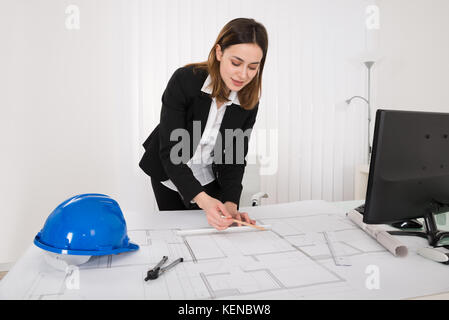 Junge glücklich weiblichen Architekten arbeiten an Blueprint im Büro Stockfoto