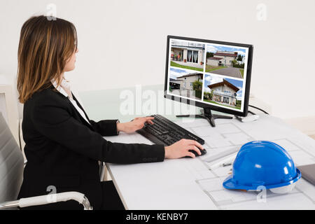 Junge weibliche Architect bei Designs von Haus auf dem Computer im Büro Stockfoto