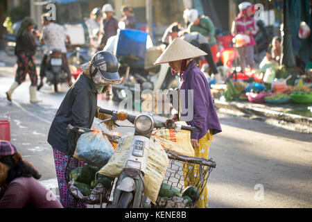 Saigon, Vietnam - Juni 2017: Frauen in den konischen Hüten Tarifverhandlungen auf Street Market, Saigon, Vietnam. Stockfoto