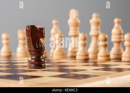 Schwarze hölzerne Schach kinght Herausforderungen weiße Seite allein. Mut gegen schwierigen Umständen. Stockfoto
