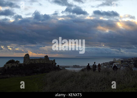 Hastings, East Sussex, 22. Okt 2017. Am Ende des Sturms Brian und, nach einem sonnigen Tag, einem Windgepeitschten Sonnenuntergang über Hastings Castle und mit schweren Gewitterwolken über der fernen Beachy Head. Stockfoto