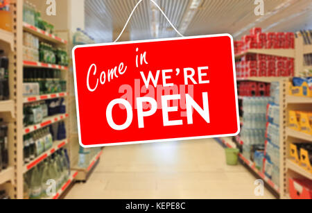 Kommen Sie herein, wir sind offen auf einem Blur Supermarkt Hintergrund Stockfoto