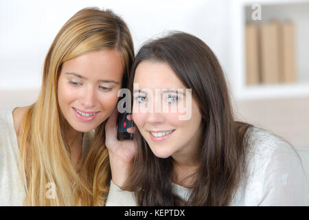 Zwei glückliche Freunde teilen ein Telefon Stockfoto