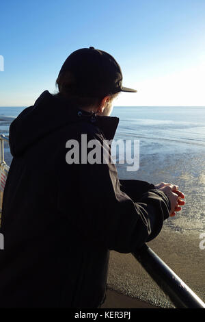 Ein junger Mann mit Blick auf das Meer Stockfoto