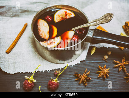 Glühwein im Aluminium Pfanne mit einer auf einem schwarzen Hintergrund Griff, vintage Toning Stockfoto