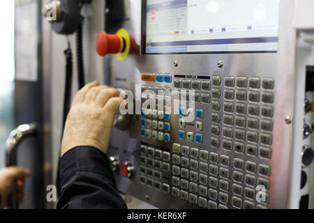 Bediener, der mit Bedienelementen der CNC-Maschine arbeitet. Selektiver Fokus. Stockfoto