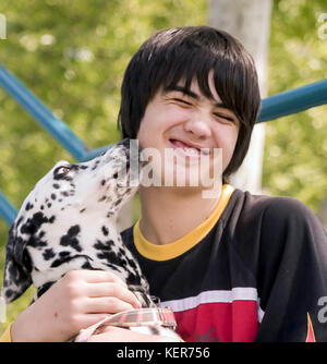 Junge Person, die spielenden Hund lecken Gesicht zeigt Zuneigung liebe treue gewidmet Grimasse Lächeln grinst 7/8 Vorderansicht schließen © Myrleen Pearson Stockfoto