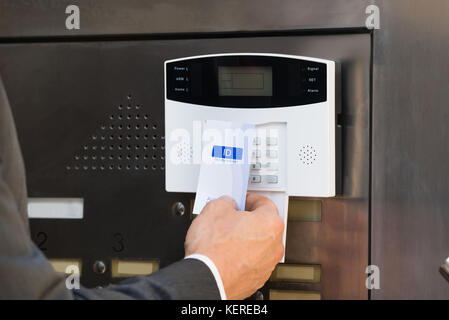 Nahaufnahme der Unternehmer die Hände einsetzen die Keycard im Sicherheitssystem von Tür zu entriegeln Stockfoto