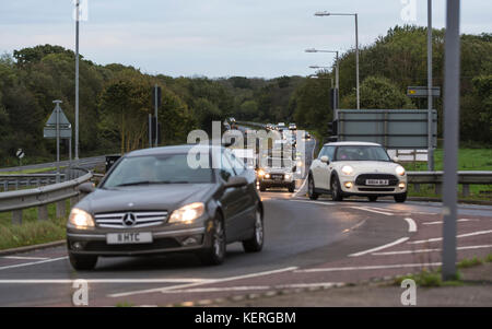 Autos mit Licht am Verkehr gefahren werden in den frühen Morgen rush-hour, auf der A27 Straße in Großbritannien. Stockfoto