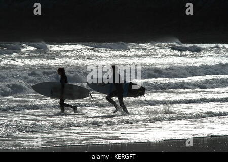 Gegen die glitzernden Wellen zwei junge Surfer das Wasser zusammen geben Sie Silhouette Stockfoto