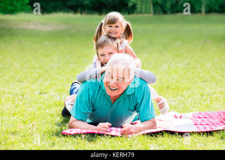 Portrait von Happy Family Spaß auf grünem Gras zusammen liegen im Park Stockfoto