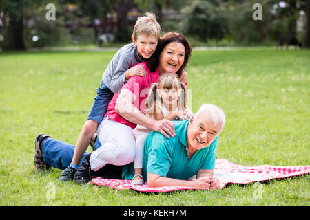 Glückliche Familie Spaß liegen auf Gras im Park Stockfoto