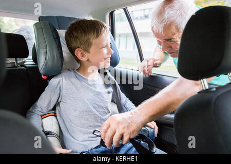 Man Knicken Sicherheitsgurt Kindersitz im Auto für Kind Stockfoto