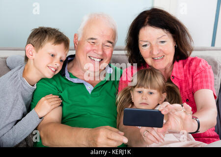 Glückliche Familie Selfie Bild mit Smartphone zu Hause Stockfoto