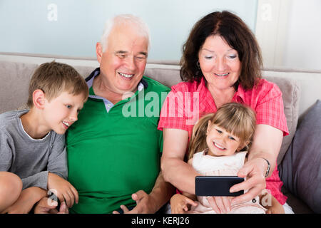 Familie mit Kindern unter Selfie Bild mit Smartphone zu Hause Stockfoto