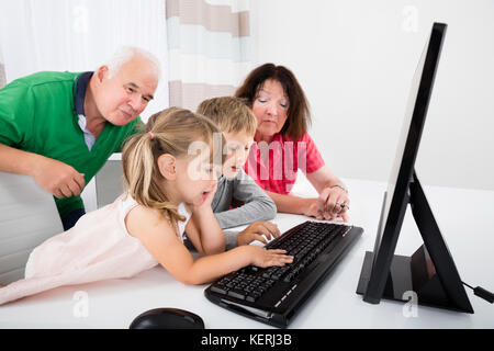 Glückliche Familie mit Laptop Computer mit Kinder zu Hause Stockfoto