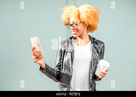 Lifestyle portrait einer afrikanischen Frau auf dem grünen Hintergrund Stockfoto