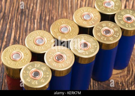 Große Patronen aus dem Gewehr stehen auf einer hölzernen Tisch in einer Zeile Stockfoto