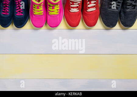 Satz von Sport Schuhe auf einem schönen Gelb Grau Hintergrund der Boden in der Halle Stockfoto