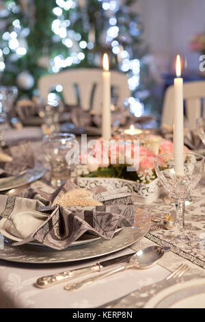 Weihnachtsbaum und ausgefallenen Tisch mit gefalteten Servietten Stockfoto