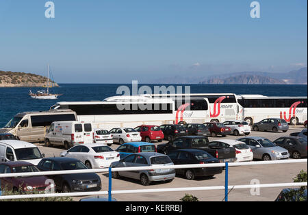 Agios Nikolaos, Kreta, Griechenland. Bus- und reisebus-Park an der Hafenfront. Blick auf das Meer und die Berge Stockfoto