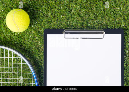 Auf einer grünen Wiese Tablet und Sachen für grosse Tennis Stockfoto