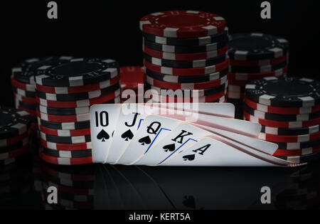 Gewinnende Kombinationen von Karten auf dem Hintergrund von Chips für Poker Spielen im Dunkeln Stockfoto