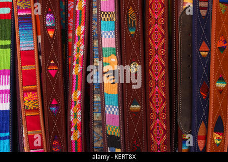 Handgefertigte bunte Textilien und Leder Riemen für Verkauf im Handwerk Markt in Otavalo, Ecuador Stockfoto