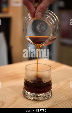 Barista gießt aus einem Sarg in das Glas Schale serviert ein Trinken. kemex Stockfoto