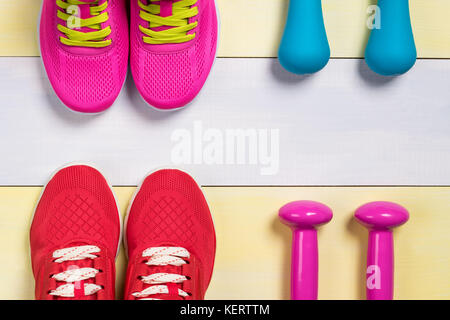 Sport Schuhe und Hanteln für Sport auf einem schönen Hintergrund grau gelb Stockfoto