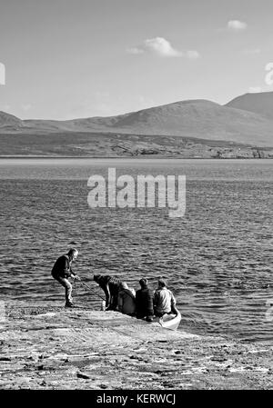 Cape Wrath Fähre, Keoldale, Kyle von Durness, Sutherland. Der Fährmann hält das Boot stabil als Beifahrer vorbereiten zum Aussteigen aus dem kleinen Beiboot. Stockfoto